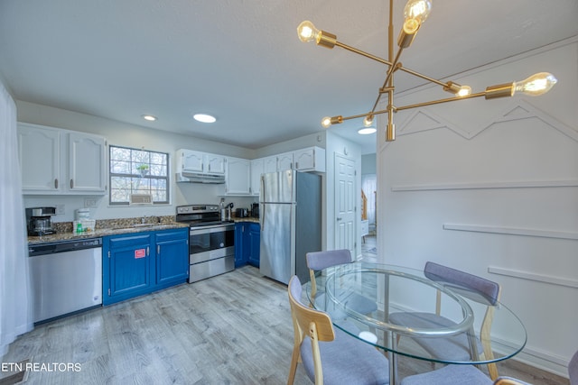 kitchen with blue cabinets, sink, appliances with stainless steel finishes, white cabinetry, and light wood-type flooring