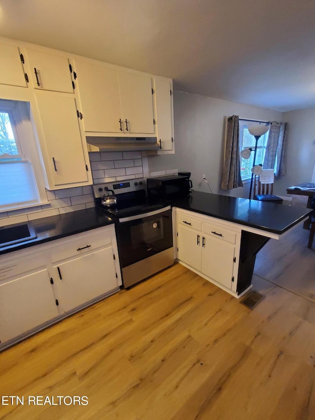 kitchen featuring tasteful backsplash, kitchen peninsula, light hardwood / wood-style flooring, stainless steel electric range oven, and white cabinets