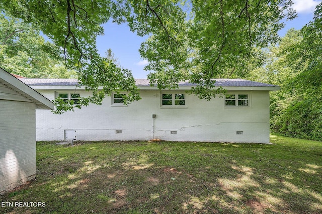 rear view of house featuring a yard