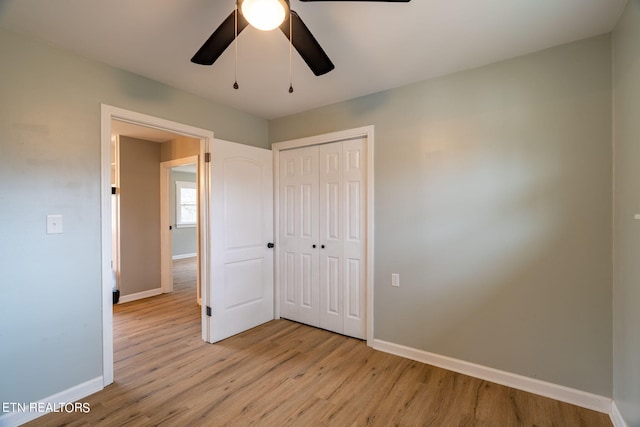 unfurnished bedroom featuring ceiling fan, a closet, and light hardwood / wood-style floors