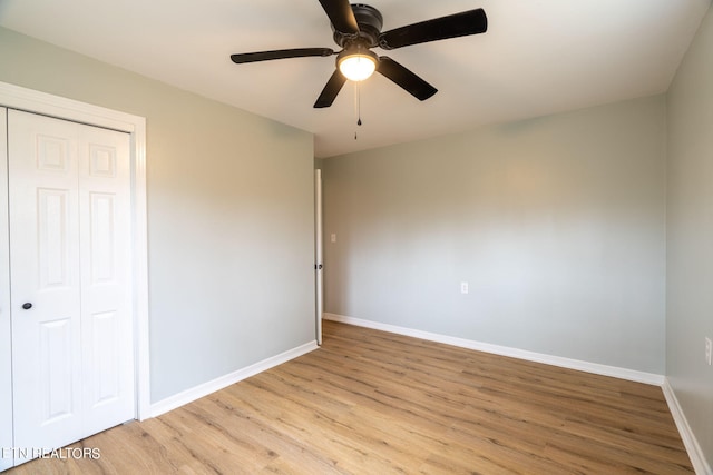 unfurnished bedroom featuring ceiling fan, a closet, and light hardwood / wood-style flooring