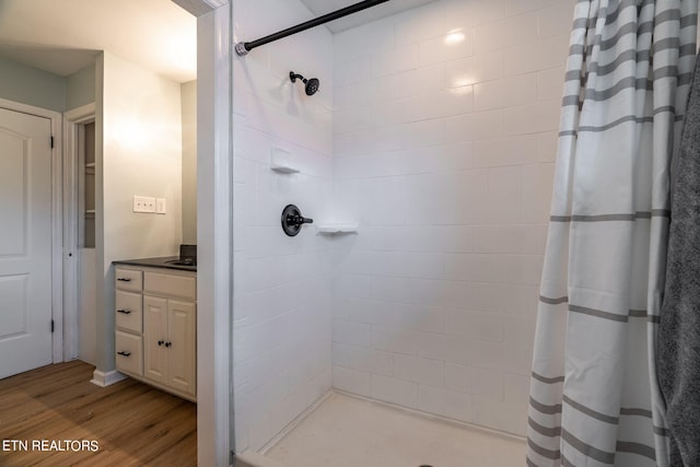 bathroom with walk in shower, wood-type flooring, and vanity