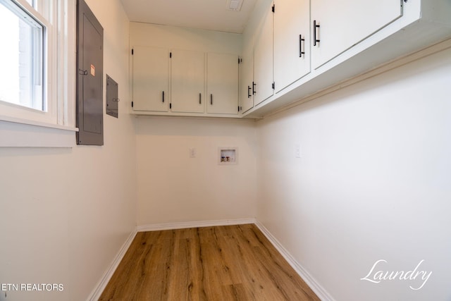 laundry area with light hardwood / wood-style floors, cabinets, electric panel, and hookup for a washing machine