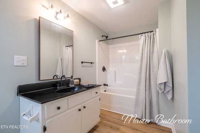 bathroom with shower / bath combo, wood-type flooring, and vanity