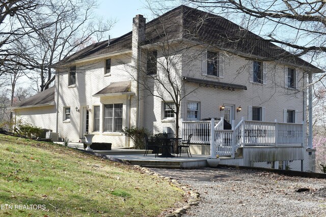 view of front facade featuring a front yard, a deck, and central air condition unit