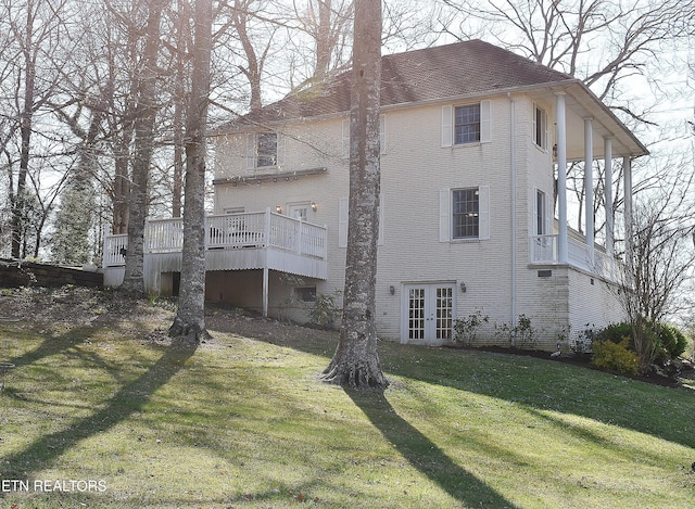 exterior space featuring a lawn, french doors, and a deck