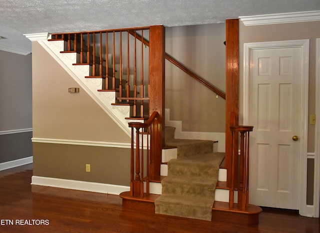 stairs featuring hardwood / wood-style flooring, ornamental molding, and a textured ceiling