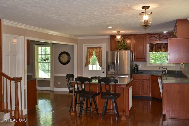 kitchen featuring sink, a center island, stainless steel fridge with ice dispenser, and a wealth of natural light