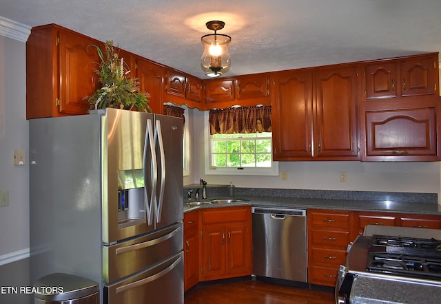 kitchen featuring dark wood-type flooring, stainless steel appliances, sink, and a textured ceiling