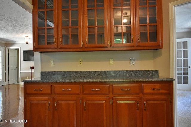 kitchen featuring ornamental molding, dark hardwood / wood-style floors, and a textured ceiling