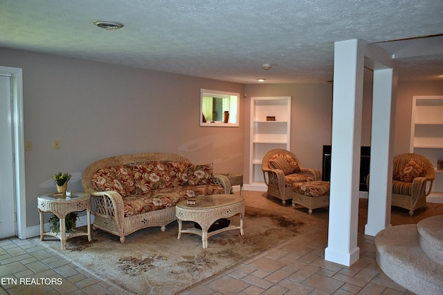 living room with a textured ceiling and built in shelves