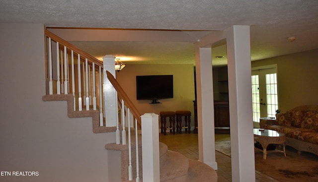 stairway featuring a textured ceiling