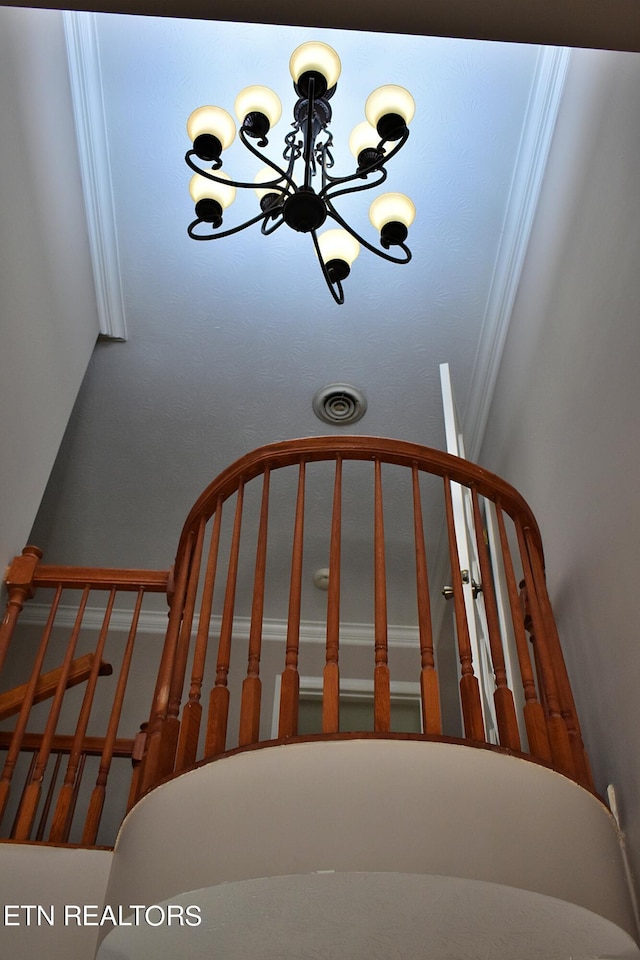 stairs with a notable chandelier