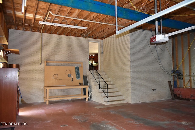 basement featuring a workshop area and brick wall