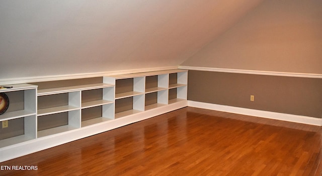 additional living space with hardwood / wood-style flooring and lofted ceiling