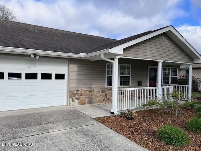 ranch-style home with covered porch and a garage