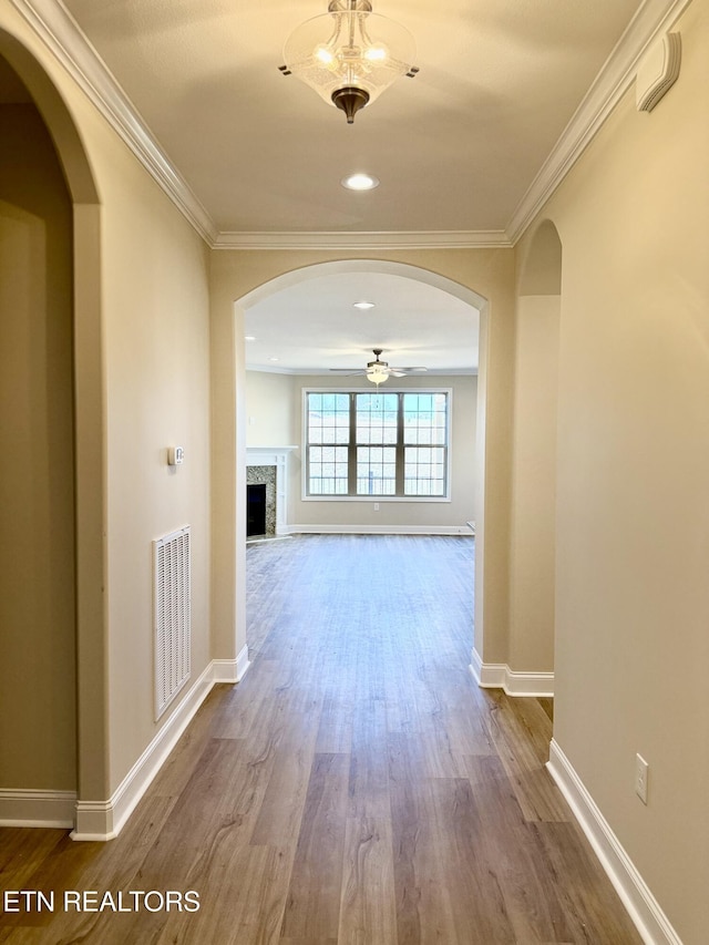 hall with hardwood / wood-style floors and crown molding