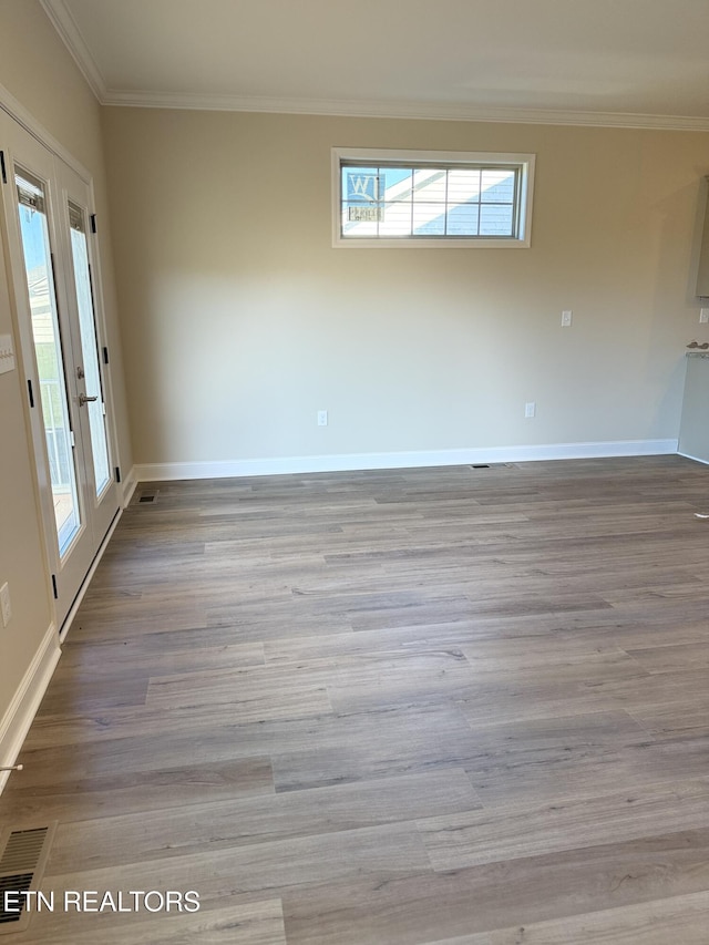 unfurnished room featuring light wood-type flooring and crown molding