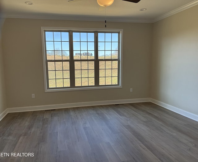 empty room with ceiling fan, dark wood-type flooring, and ornamental molding