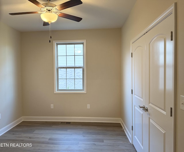 spare room featuring ceiling fan and dark wood-type flooring