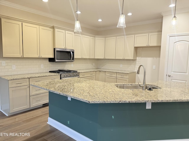 kitchen featuring decorative light fixtures, sink, light stone counters, appliances with stainless steel finishes, and crown molding