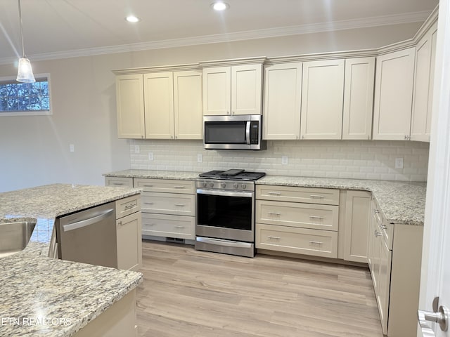 kitchen with appliances with stainless steel finishes, crown molding, hanging light fixtures, and light stone counters