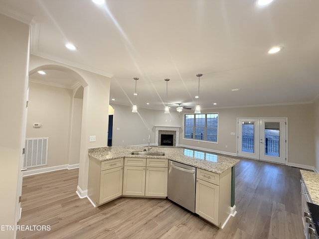 kitchen with crown molding, dishwasher, light stone counters, and sink