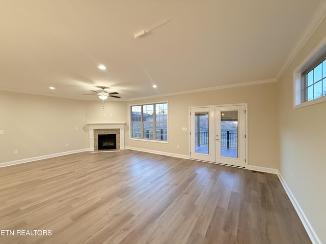 unfurnished living room featuring light hardwood / wood-style floors, french doors, crown molding, and ceiling fan