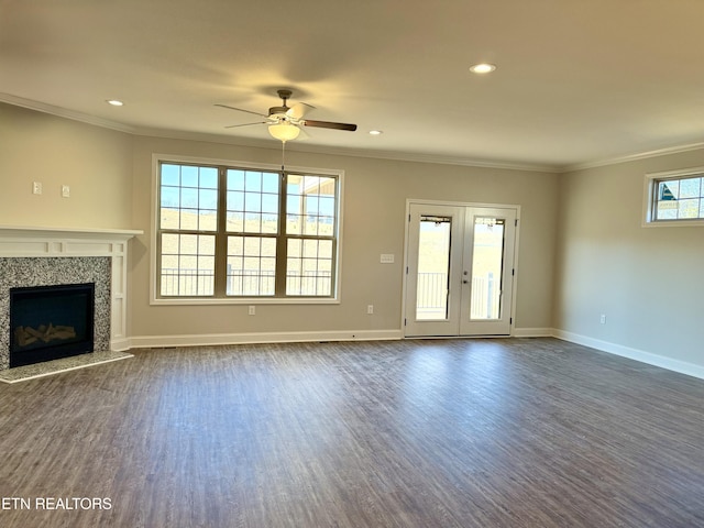 unfurnished living room featuring a fireplace, french doors, ceiling fan, dark wood-type flooring, and crown molding