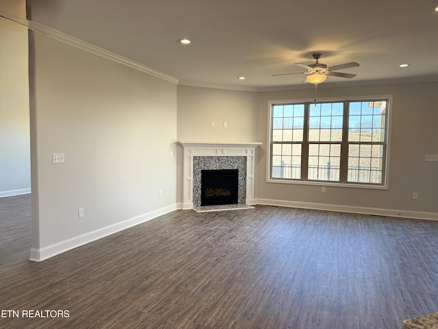 unfurnished living room featuring a tiled fireplace, crown molding, and dark hardwood / wood-style flooring