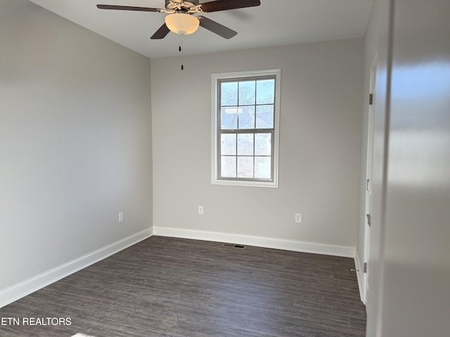 spare room with ceiling fan and dark wood-type flooring