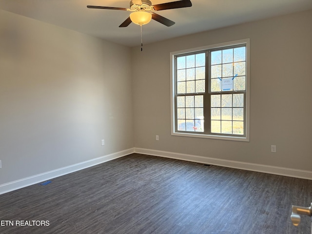 empty room with ceiling fan and dark wood-type flooring