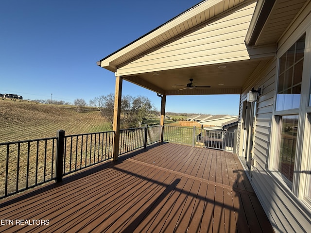 wooden deck featuring ceiling fan and a rural view