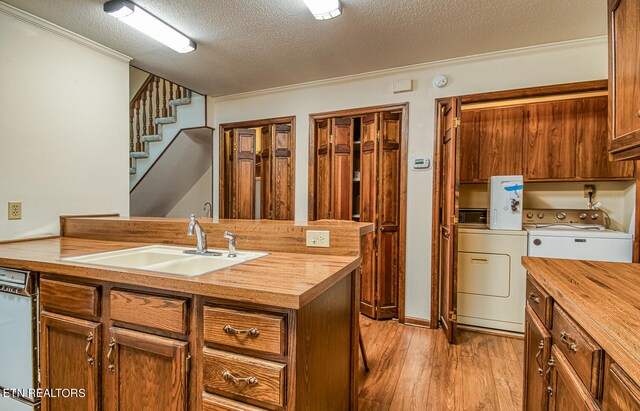 kitchen featuring wood counters, dishwasher, sink, independent washer and dryer, and a textured ceiling