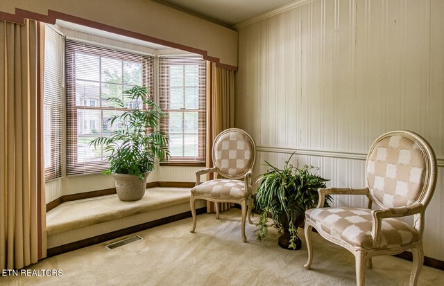 living area with light carpet and ornamental molding