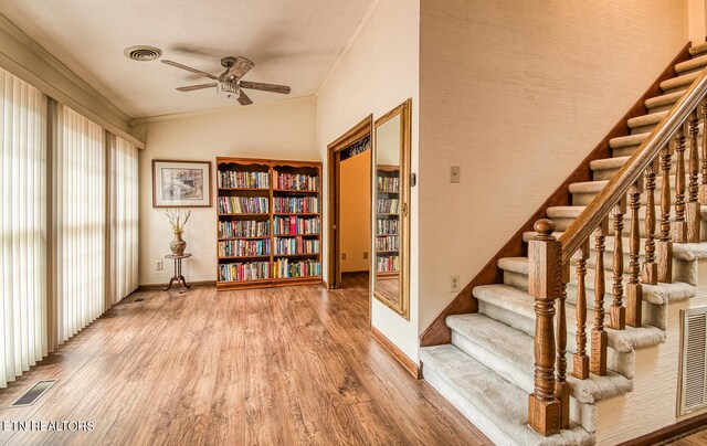 interior space with wood-type flooring, vaulted ceiling, ceiling fan, and crown molding