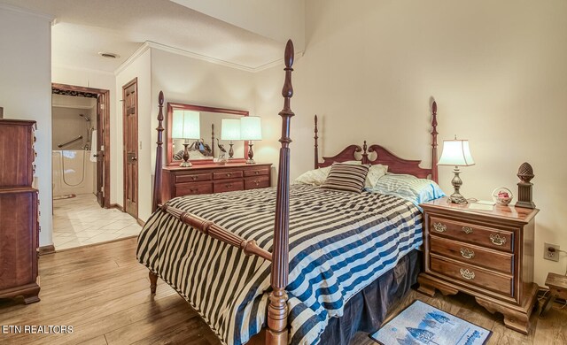 bedroom with connected bathroom, crown molding, and light hardwood / wood-style flooring