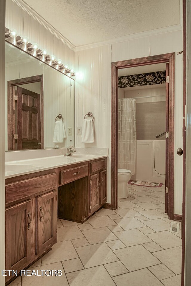 bathroom featuring crown molding, vanity, a textured ceiling, and toilet