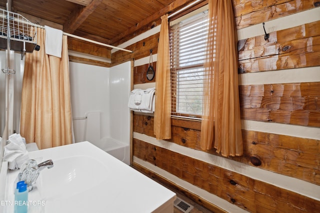 bathroom featuring shower / bathtub combination with curtain, sink, a wealth of natural light, and wood ceiling