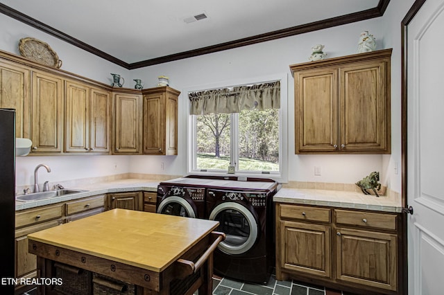 kitchen featuring sink, washing machine and dryer, black fridge, dark tile patterned flooring, and ornamental molding