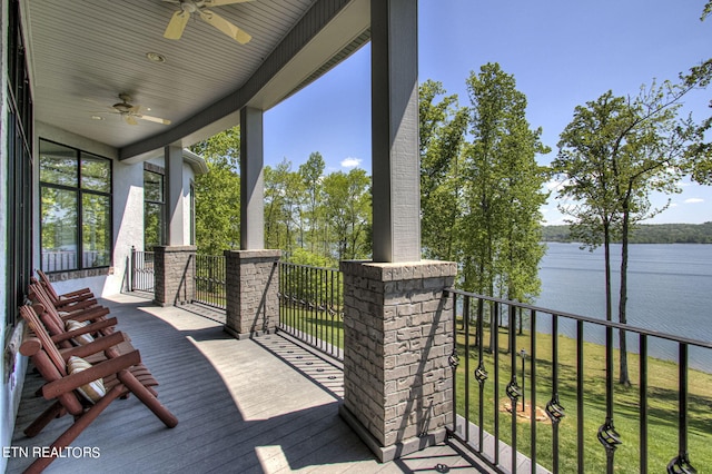 wooden terrace with ceiling fan and a water view