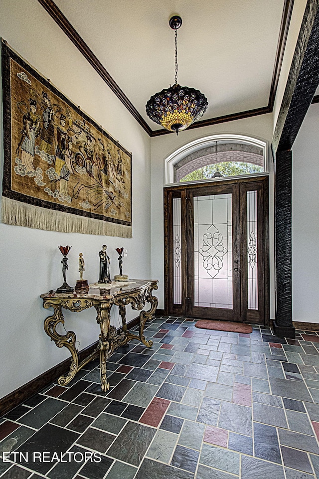 entrance foyer with a towering ceiling and crown molding