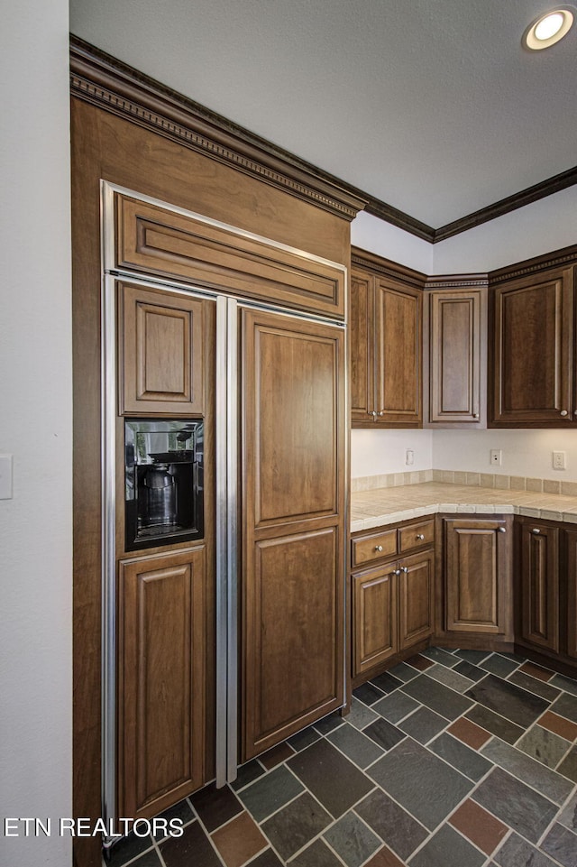 kitchen featuring crown molding and paneled fridge