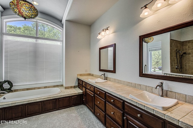 bathroom with vanity, shower with separate bathtub, and a wealth of natural light