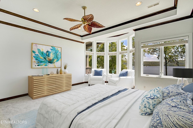 carpeted bedroom featuring a tray ceiling, ceiling fan, and crown molding