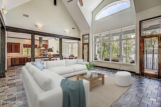 living room featuring ceiling fan, plenty of natural light, and high vaulted ceiling