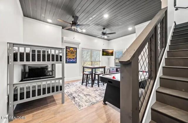 interior space with wood ceiling, a wall unit AC, ceiling fan, and light hardwood / wood-style flooring