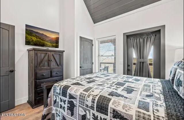 bedroom with high vaulted ceiling and light wood-type flooring