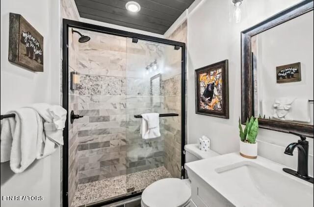 bathroom with a shower with door, toilet, and vanity