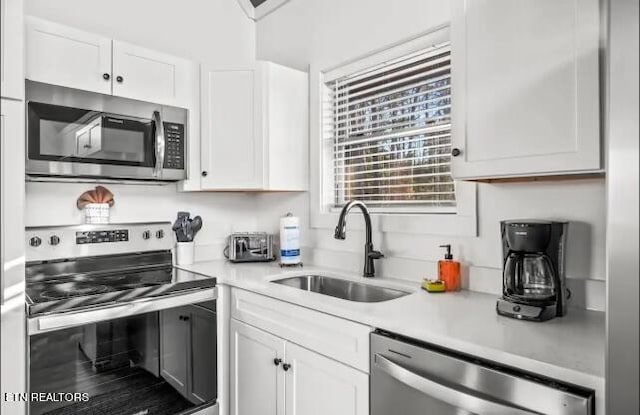 kitchen with white cabinets, stainless steel appliances, and sink